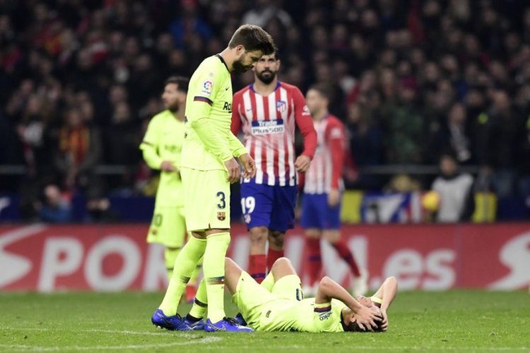 Barcelona's Spanish defender Gerard Pique (L) checks on Barcelona's Spanish midfielder Sergi Roberto as he lies on the ground during the Spanish league football match between Club Atletico de Madrid and FC Barcelona at the Wanda Metropolitano stadium in Madrid on November 24, 2018. (Photo by JAVIER SORIANO / AFP)        (Photo credit should read JAVIER SORIANO/AFP via Getty Images)