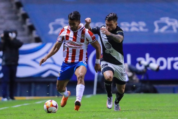 PUEBLA, MEXICO - JANUARY 08: Miguel Ponce #16 of Chivas struggles for the ball against Christian Tabó #10 of Puebla during the 1st round match between Puebla FC and Chivas as part of the Torneo Guard1anes 2021 Liga MX at Cuauhtemoc Stadium on January 08, 2021 in Puebla, Mexico. (Photo by Manuel Velasquez/Getty Images)
