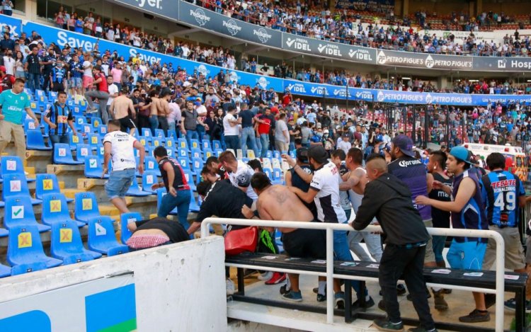 Supporters of Atlas fight with supporters of Queretaro during the Mexican Clausura tournament football match between Queretaro and Atlas at Corregidora stadium in Queretaro, Mexico on March 5, 2022. - A match between Mexican football clubs was called off March 5, 2022 after violence by opposing fans spilled onto the field. The game between Queretaro and Atlas at La Corregidora stadium in the city of Queretaro  -- the ninth round of the 2022 Clausura football tournament -- was in its 63rd minute when fights between opposing fans broke out. (Photo by EDUARDO GOMEZ / AFP) (Photo by EDUARDO GOMEZ/AFP via Getty Images)