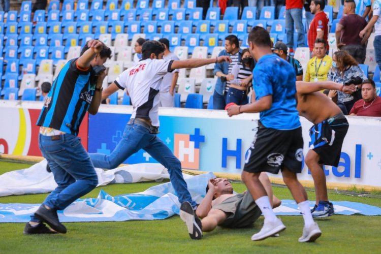 QUERETARO, MEXICO - MARCH 05: Fans fight during the 9th round match between Queretaro and Atlas as part of the Torneo Grita Mexico C22 Liga MX at La Corregidora Stadium on March 05, 2022 in Queretaro, Mexico. The match was suspended on the 60th minute due to violent fights between fans. (Photo by Manuel Velasquez/Getty Images)