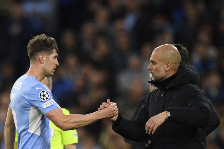 Manchester City's English defender John Stones is congratulated by Manchester City's Spanish manager Pep Guardiola as he leaves the pitch during the UEFA Champions League semi-final first leg football match between Manchester City and Real Madrid, at the Etihad Stadium, in Manchester, on April 26, 2022. (Photo by Oli SCARFF / AFP) (Photo by OLI SCARFF/AFP via Getty Images)