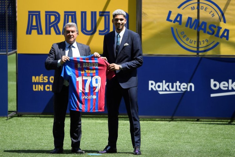 Barcelona's Uruguayan defender Ronald Araujo (R) pose for pictures with Barcelona's Spanish President Joan Laporta holding his jersey during a contract renewal signing ceremony, at the Camp Nou stadium in Barcelona on April 29, 2022. - Barcelona defender Ronald Araujo has agreed a new contract until 2026 with a buy-out clause set at 1 billion euros. (Photo by Josep LAGO / AFP) (Photo by JOSEP LAGO/AFP via Getty Images)