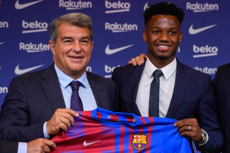 Barcelona's Spanish midfielder Ansu Fati (R) and President of FC Barcelona Joan Laporta pose for pictures during his contract renewal signing ceremony in Barcelona, on October 21, 2021. - Ansu Fati has extended his contract with Barcelona until 2027, the club announced on October 20, shortly after their 1-0 victory over Dynamo Kiev in the Champions League. (Photo by Josep LAGO / AFP) (Photo by JOSEP LAGO/AFP via Getty Images)