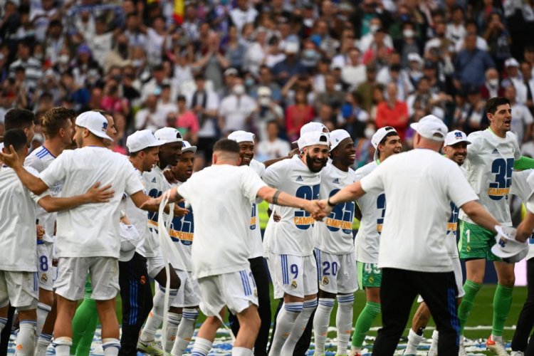 Real Madrid's players celebrate at the end of the Spanish League football match between Real Madrid CF and RCD Espanyol at the Santiago Bernabeu stadium in Madrid on April 30, 2022. - Real Madrid secured a 35th La Liga title with four games to spare after a 4-0 home win over Espanyol that included two goals from Rodrygo. Needing just one point to clinch the trophy, Madrid struck twice through the Brazilian in the first half at the Santiago Bernabeu before further goals from Marco Asensio and Karim Benzema. (Photo by GABRIEL BOUYS / AFP) (Photo by GABRIEL BOUYS/AFP via Getty Images)