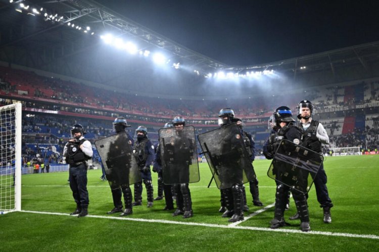 Police officers face Lyon's supporters after the UEFA Europa League quarter-final second-leg football match between Olympique Lyonnais (OL) and West Ham United at the Groupama stadium in Decines-Charpieu near Lyon, central eastern France, on April 14, 2022. (Photo by Jeff PACHOUD / AFP) (Photo by JEFF PACHOUD/AFP via Getty Images)