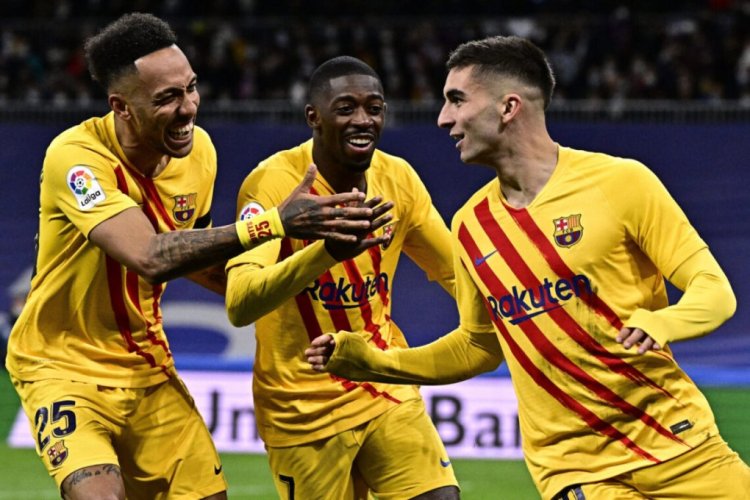 TOPSHOT - Barcelona's Spanish forward Ferran Torres (R) celebrates with Barcelona's Gabonese midfielder Pierre-Emerick Aubameyang (L) and Barcelona's French forward Ousmane Dembele (C) after scoring a goal during the Spanish League football match between Real Madrid CF and FC Barcelona at the Santiago Bernabeu stadium in Madrid on March 20, 2022. (Photo by JAVIER SORIANO / AFP) (Photo by JAVIER SORIANO/AFP via Getty Images)