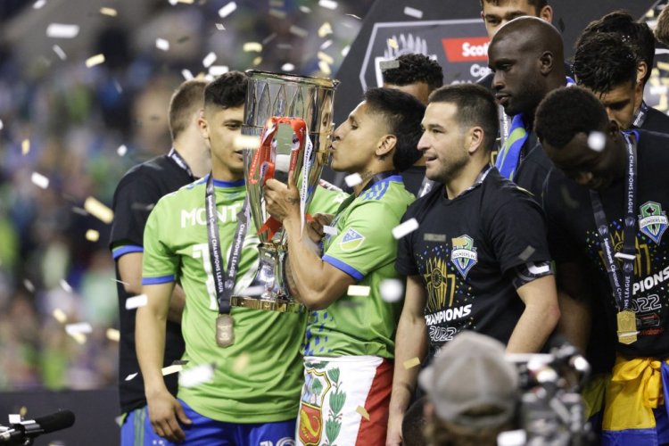 Seattle Sounders forward Raul Ruidiaz kisses the trophy as the team celebrates their victory in the CONCACAF Champions League final match between Seattle Sounders and Pumas UNAM at Lumen Field in Seattle, Washington on May 4, 2022. - The Seattle Sounders defeated Mexico's Pumas UNAM 5-2 on aggregate to win the CONCACAF Champions League on Wednesday, ending Major League Soccer's 23-year wait to lift the top club tournament for teams from North America, Central America and the Caribbean. (Photo by Jason Redmond / AFP) (Photo by JASON REDMOND/AFP via Getty Images)