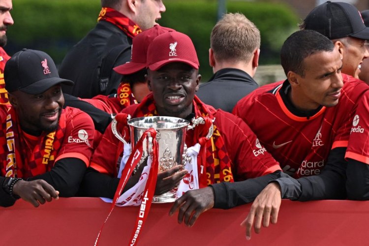 Liverpool's Senegalese striker Sadio Mane (C) holds the League Cup trophy as Liverpool's players take their places on an open-top bus for a parade through the streets of Liverpool in north-west England on May 29, 2022, to celebrate winning the 2021-22 League Cup and FA Cup. - Despite the disappointment of losing to real Madrid in the final of the UEAF Champions League, Klopp has called on Liverpool fans to take to the streets of the city on Sunday when they parade the League Cup and FA Cup. (Photo by Oli SCARFF / AFP) (Photo by OLI SCARFF/AFP via Getty Images)