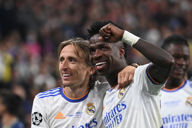 Real Madrid's Brazilian striker Vinicius Junior (R) and Real Madrid's Croatian midfielder Luka Modric (L) celebrate Real Madrid's victory in the UEFA Champions League final football match between Liverpool and Real Madrid at the Stade de France in Saint-Denis, north of Paris, on May 28, 2022. (Photo by Anne-Christine POUJOULAT / AFP) (Photo by ANNE-CHRISTINE POUJOULAT/AFP via Getty Images)