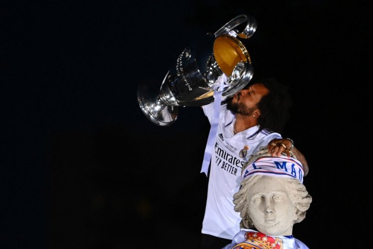 Real Madrid's Brazilian defender Marcelo kisses their trophy ontop of the statue of Greek goddess Cybele on May 29, 2022 at the Cibeles square in Madrid, a day after beating Liverpool in the UEFA Champions League final in Paris. - Real Madrid claimed a 14th European Cup as Vinicius Junior's goal saw them beat Liverpool 1-0 in the Champions League final at the Stade de France amid chaotic scenes yesterday. (Photo by GABRIEL BOUYS / AFP) (Photo by GABRIEL BOUYS/AFP via Getty Images)