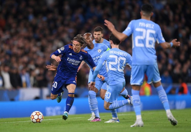 MANCHESTER, ENGLAND - APRIL 26: Luka Modric of Real Madrid is challenged by Fernandinho and Bernardo Silva of Manchester City during the UEFA Champions League Semi Final Leg One match between Manchester City and Real Madrid at Etihad Stadium on April 26, 2022 in Manchester, England. (Photo by Laurence Griffiths/Getty Images)