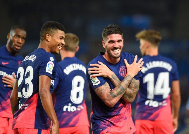 Atletico Madrid's Argentinian midfielder Rodrigo De Paul (R) celebrates with teammates after scoring his team's first goal during the Spanish League football match between Real Sociedad and Club Atletico de Madrid at the Anoeta stadium in San Sebastian on May 22, 2022. (Photo by ANDER GILLENEA / AFP) (Photo by ANDER GILLENEA/AFP via Getty Images)