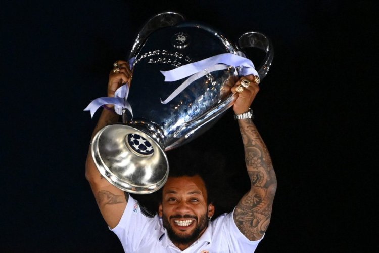 Real Madrid's Brazilian defender Marcelo lifts their trophy ontop of the statue of Greek goddess Cybele on May 29, 2022 at the Cibeles square in Madrid, a day after beating Liverpool in the UEFA Champions League final in Paris. - Real Madrid claimed a 14th European Cup as Vinicius Junior's goal saw them beat Liverpool 1-0 in the Champions League final at the Stade de France amid chaotic scenes yesterday. (Photo by GABRIEL BOUYS / AFP) (Photo by GABRIEL BOUYS/AFP via Getty Images)