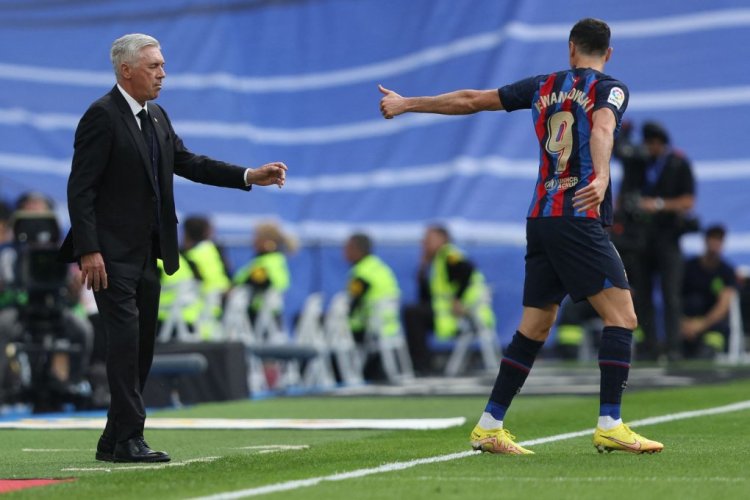 Real Madrid's Italian coach Carlo Ancelotti (L) and Barcelona's Polish forward Robert Lewandowski gesture to each other during the Spanish League football match between Real Madrid CF and FC Barcelona at the Santiago Bernabeu stadium on October 16, 2022. (Photo by Thomas COEX / AFP) (Photo by THOMAS COEX/AFP via Getty Images)