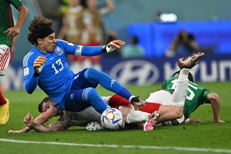 Poland's forward #09 Robert Lewandowski (bottom) is fouled by Mexico's defender #15 Hector Moreno (R) next to Mexico's goalkeeper #13 Guillermo Ochoa (top) and is awarded a penalty during the Qatar 2022 World Cup Group C football match between Mexico and Poland at Stadium 974 in Doha on November 22, 2022. (Photo by MANAN VATSYAYANA / AFP) (Photo by MANAN VATSYAYANA/AFP via Getty Images)