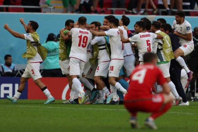 Iran's players celebrate the team's victory during the Qatar 2022 World Cup Group B football match between Wales and Iran at the Ahmad Bin Ali Stadium in Al-Rayyan, west of Doha on November 25, 2022. (Photo by Adrian DENNIS / AFP) (Photo by ADRIAN DENNIS/AFP via Getty Images)