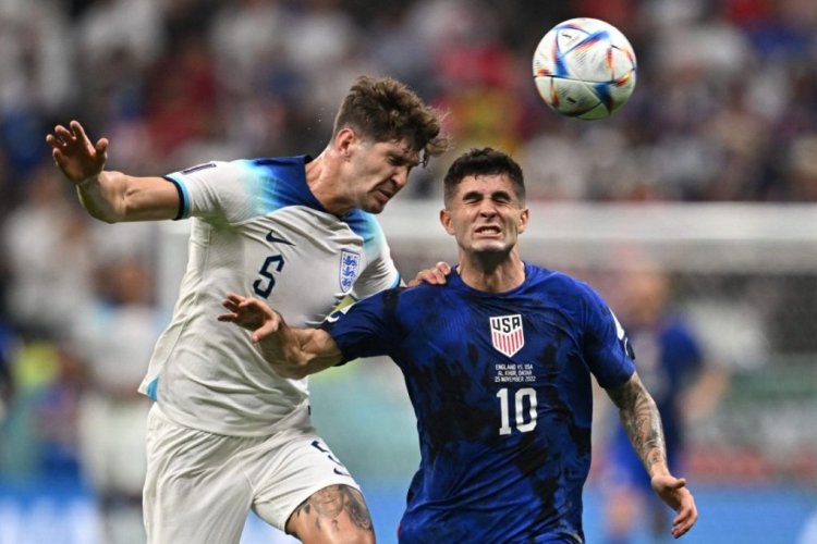 England's defender #05 John Stones (L) and USA's forward #10 Christian Pulisic fight for the ball during the Qatar 2022 World Cup Group B football match between England and USA at the Al-Bayt Stadium in Al Khor, north of Doha on November 25, 2022. (Photo by Paul ELLIS / AFP) (Photo by PAUL ELLIS/AFP via Getty Images)