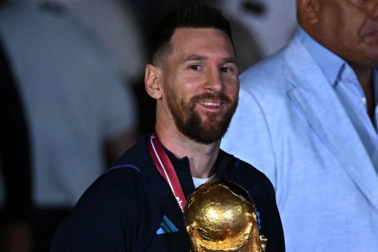 Argentina's captain and forward Lionel Messi (C) holds the FIFA World Cup Trophy upon arrival at Ezeiza International Airport after winning the Qatar 2022 World Cup tournament in Ezeiza, Buenos Aires province, Argentina on December 20, 2022. (Photo by Luis ROBAYO / AFP) (Photo by LUIS ROBAYO/AFP via Getty Images)