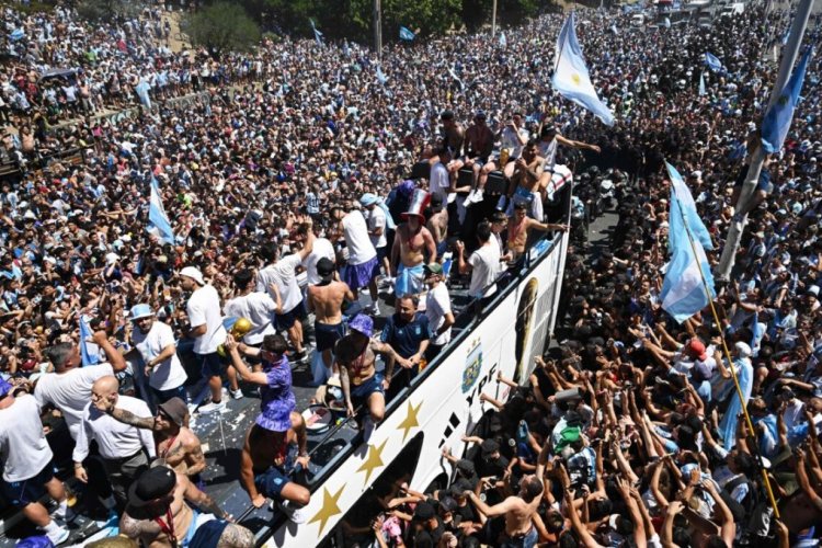 Argentina's players celebrate on board a bus with a sign reading "World Champions" with supporters after winning the Qatar 2022 World Cup tournament as they tour through Buenos Aires' downtown on December 20, 2022. - Millions of ecstatic fans are expected to cheer on their heroes as Argentina's World Cup winners led by captain Lionel Messi began their open-top bus parade of the capital Buenos Aires on Tuesday following their sensational victory over France. (Photo by Luis ROBAYO / AFP) (Photo by LUIS ROBAYO/AFP via Getty Images)