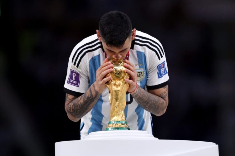LUSAIL CITY, QATAR - DECEMBER 18: Cristian Romero of Argentina kisses the FIFA World Cup winning trophy during the award ceremony following the FIFA World Cup Qatar 2022 Final match between Argentina and France at Lusail Stadium on December 18, 2022 in Lusail City, Qatar. (Photo by Clive Brunskill/Getty Images)