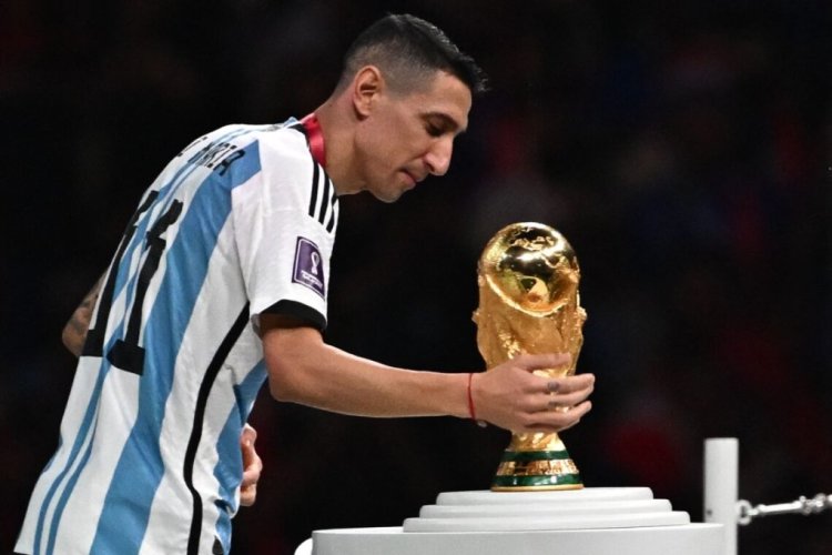 Argentina's midfielder #11 Angel Di Maria touches the FIFA World Cup Trophy during the trophy ceremony after Argentina won the Qatar 2022 World Cup final football match between Argentina and France at Lusail Stadium in Lusail, north of Doha on December 18, 2022. (Photo by Anne-Christine POUJOULAT / AFP) (Photo by ANNE-CHRISTINE POUJOULAT/AFP via Getty Images)