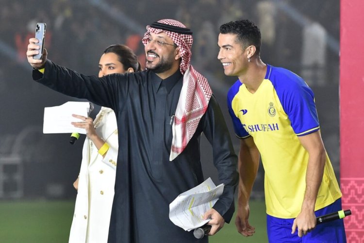 Al-Nassr's new Portuguese forward Cristiano Ronaldo (R) poses for a selfie with the presenters during his unveiling at the Mrsool Park Stadium in the Saudi capital Riyadh on January 3, 2023. (Photo by AFP) (Photo by -/AFP via Getty Images)