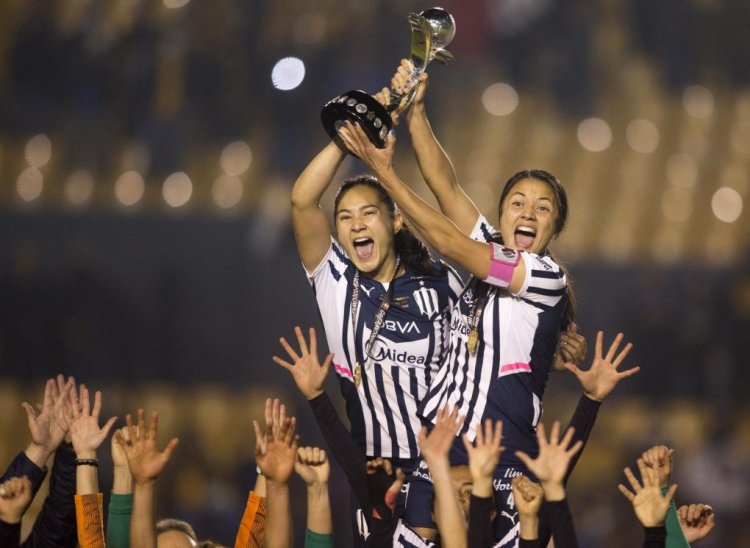 Desiree Monsivais (L) and Rebeca Bernal (R) of Rayadas of Monterrey celebrate with the trophy after winning the Liga MX Femenil Apertura 2021 football tournament by defeating Tigres Femenil at Universitario stadium in Monterrey, Mexico, on December 20, 2021. (Photo by Julio Cesar AGUILAR / AFP) (Photo by JULIO CESAR AGUILAR/AFP via Getty Images)